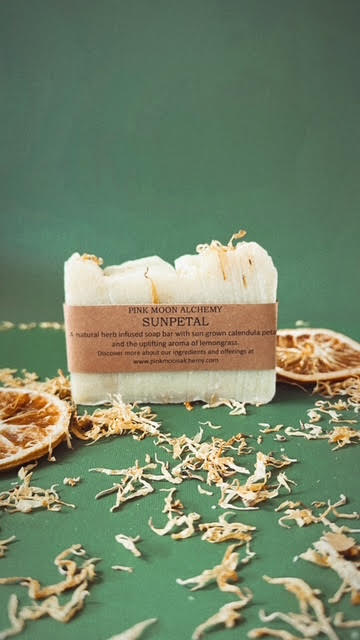 Bar of soap with a label on a green background with dried herbs