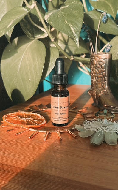 Bottle of Vision Keeper Herbal Elixir on a wooden surface with plants in the background